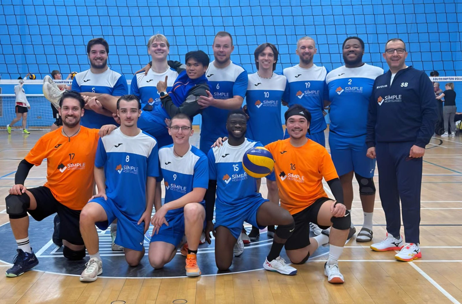 Portsmouth United Volleyball Club players and Head Coach Samir Belaiche line up on court at Itchen College Sports Centre